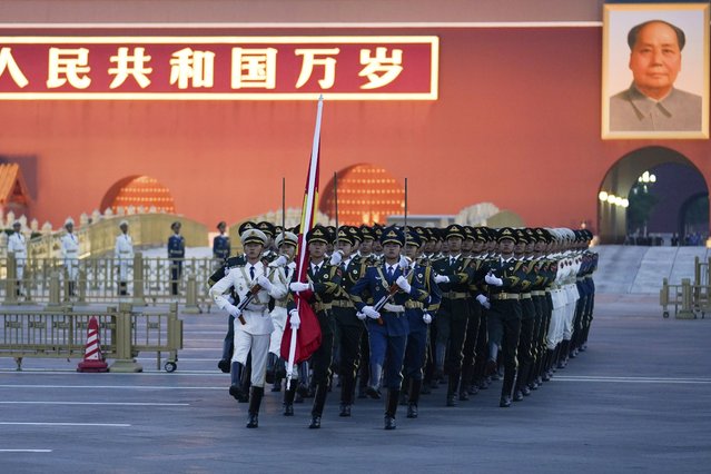 In this photo released by Xinhua News Agency, a Chinese honor guard march to a flag raising ceremony to mark the 73rd anniversary of the founding of the People's Republic of China held at the Tiananmen Square in Beijing on Saturday, October 1, 2022. (Photo by Ju Huanzong/Xinhua via AP Photo)