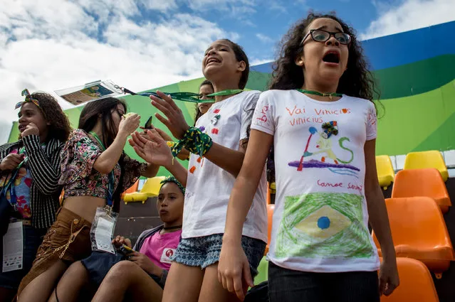Children from the Cantagalo favel community react while watching matches during the Olympic Rugby 7's on August 11, 2016 in Rio de Janeiro, Brazil. A small group of children were surprised with tickets to the Olympics after staff and volunteers from their English language school the Caminhos Language Centre, arranged to buy tickets for them. The kids were given Olympic merchandise bags, a trip to McDonalds and tickets to a session at the Olympic Rugby 7s event. Generally, tickets to the Olympics are out of reach for many Brazilians, families from underprivileged areas such as favelas have very little opportunity to see the Olympics live. (Photo by Chris McGrath/Getty Images)