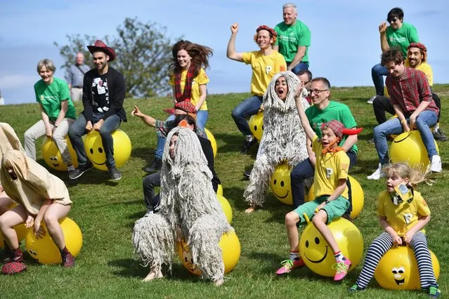 Comedians and cast members from the Pleasance's 2016 programme bounce on yellow spacehoppers in costume at Calton Hill on August 15, 2016 in Edinburgh, Scotland. (Photo by Jeff J. Mitchell/Getty Images)