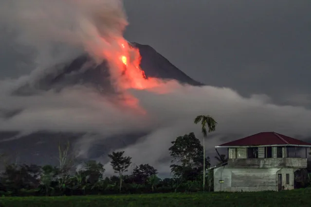 This slow- shutter speed photograph shows the eruption of Mount Sinabung volcano as seen from Simpang Ampat village, in Karo, North Sumatra, on November 10, 2017. Sinabung roared back to life in 2010 for the first time in 400 years, after another period of inactivity it erupted once more in 2013, and has remained highly active since. (Photo by  Ivan Damanik/AFP Photo)