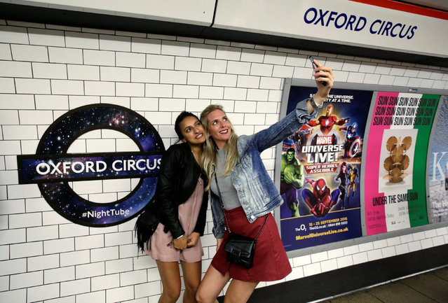 Passengers pose for a selfie as they wait for the Night Tube train service at Oxford Circus on the London underground system in London, Britain August 20, 2016. The London Underground is starting its first-ever overnight service, a move city leaders hope will make the British capital a truly 24-hour city and bolster the local economy. The new service will only run on weekends and initially be available on just the well-traveled Central and Victoria lines. But the initiative reflects London’s growing population and cosmopolitan mentality, marking a coming of age for a city that many in the Big Apple regard as quaint and sleepy. (Photo by Paul Hackett/Reuters)