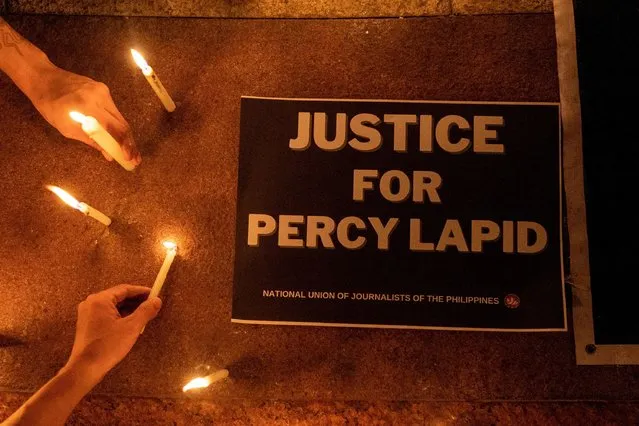 Journalists and activists light candles for killed Filipino radio journalist Percival Mabasa during an indignation rally, in Quezon City, Philippines on October 4, 2022. Mabasa, 63, was killed by two assailants at the gate of a residential compound in the Las Pinas area of Manila on October 3, 2022. (Photo by Eloisa Lopez/Reuters)