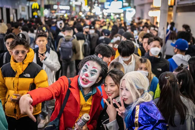 People wearing costumes pose for photographs as they take part in Halloween celebrations in the Shibuya district of Tokyo on October 30, 2022. (Photo by Yuichi Yamazaki/AFP Photo)