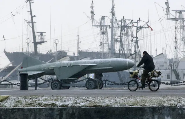A man rides a bike past a Soviet era rocket at a Navy base in Kronstadt, a seaport town 30 km (19 miles) west of St. Petersburg, Russia, Monday, December 4, 2017. (Photo by Dmitri Lovetsky/AP Photo)