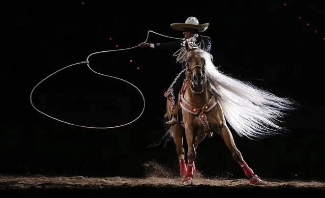 A rodeo performer does rope tricks at the end of the 10th go-round of the National Finals Rodeo in Las Vegas, December 15, 2012. (Photo by Julie Jacobson/Associated Press)