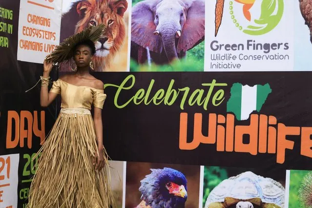Model Obum Daniel Amarachukwu wears an outfit made from recycled palm front poses for a photograph at the green carpet before a “trashion show” in Sangotedo Lagos, Nigeria, Saturday, November 19, 2022. (Photo by Sunday Alamba/AP Photo)