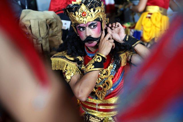 A male Imblig Dhem dancer has some final touches applied to his make-up as he waits his turn during a traditional dance performance at a village in Wonosobo, Indonesia, 19 April 2025. Imblig Dhem Dance, also known as Kuda Kepang or horse braid dance, is a popular dance that is famous for being very energetic. Usually this dance is performed by 15-20 young dancers, both male and female, dressed in traditional clothes, accompanied by Javanese music, namely Gamelan. The dance uses a horse-drawn carriage made of woven bamboo and depicts horsemen practicing war. Imblig Dhem is a prime example of the numerous traditional Central Javanese arts that are still being preserved. (Photo by Adi Weda/EPA)