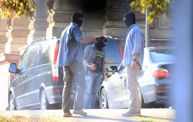 German plain clothes policemen stand outside the German Supreme Court (BGH) as one of three terrorism suspects arrives to be brought before the investigating judge in Karlsruhe, Germany, 14 September 2016. The three Syrians were arrested in anti-terrorism raids on Tuesday morning in the German states of Schleswig-Holstein and Lower Saxony. According to German Press Agency information, the suspects were arrested in Ahrensburg and Grosshansdorf east of Hamburg, as well as in Reinfeld near Luebeck, where they were living in communal refugee accommodation centres. (Photo by Uli Deck/EPA)