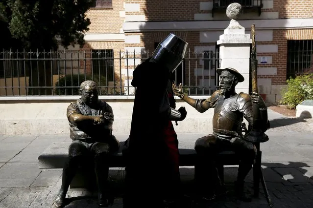 An actor performing as a knight stands next to statues of Don Quixote (R) and Sancho Panza, the two main characters from the famous novel by Spanish writer Miguel de Cervantes, "Don Quixote", during the annual Cervantes market (Mercado Cervantino) in Cervantes' hometown Alcala de Henares, Spain, October 9, 2015. (Photo by Susana Vera/Reuters)