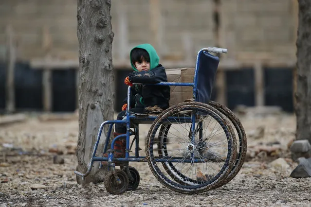 A Syrian child sits on a wheelchair after he and the family crossed into Turkey, in the Oncupinar border crossing with Syria, known as Bab al Salameh in Arabic, in the outskirts of the town of Kilis, Turkey, Friday, January 26, 2018. The Kurdish-led Syrian Democratic Forces says the first week of Turkey’s incursion into the Syrian Kurdish enclave of Afrin has left more than a 100 civilians and fighters dead. (Photo by Lefteris Pitarakis/AP Photo)