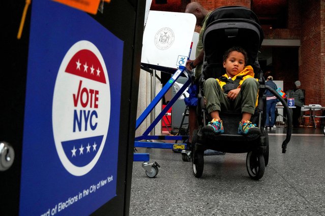 A child in a stroller looks on, as people vote during early voting in the New York primary election at the Brooklyn Museum in New York on June 22, 2025. (Photo by Eduardo Munoz/Reuters)