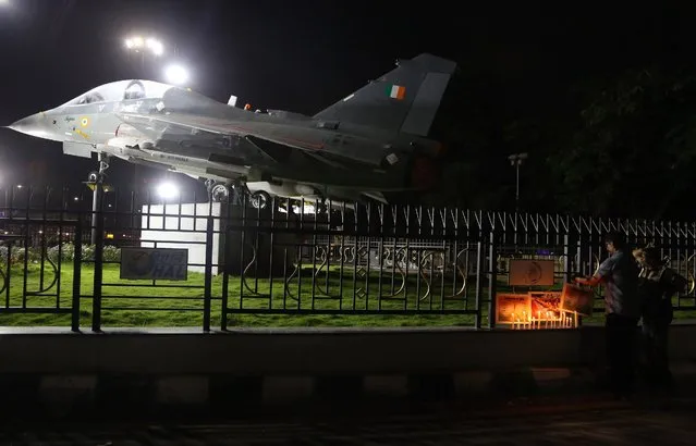 People place photographs and candles next to a model of Tejas, an Indian Air Force light combat aircraft, as they pay tribute to the Indian soldiers killed in the Sunday attack on army base in Indian-controlled Kashmir, in Bangalore, India, Monday, September 19, 2016. India's prime minister came under increasing pressure Monday from within his own party, as many in the country demanded a strong response to a deadly weekend attack that the government blames on Pakistan-based militants. (Photo by Aijaz Rahi/AP Photo)