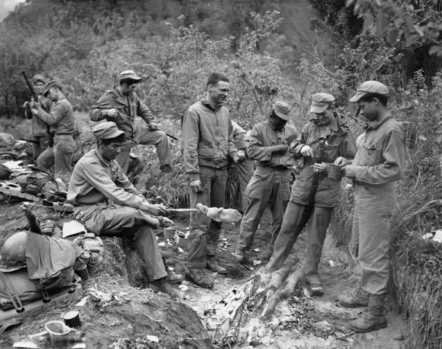 United Nations soldiers eat, rest, dry their clothing and clean their rifles, as they get a brief respite on the east central front in Korea on June 3, 1951. In immediate foreground (left to right) are: Cpl. Raymond Sandoval, Santa Fe. N.M.; Pfc. John Stevens, Jr., Oceanside, Calif.; Pfc. Jerry Dean Walter, England, Ark.; Pfc. Henry Petty, Chicago; and Cpl. Richard Younger, New York City. (Photo by E.N Johnson/AP Photo)