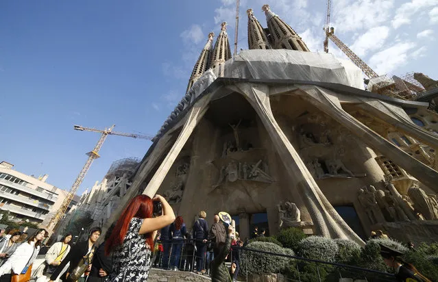 Visitors of the Sagrada Familia Basilica, designed by architect Antoni Gaudi, in Barcelona, Spain, Wednesday, October 21, 2015. (Photo by Manu Fernandez/AP Photo)
