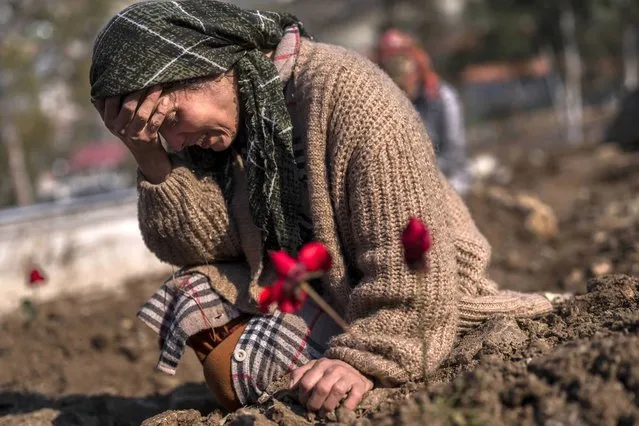 A member of the Vehibe family mourns a relative during the burial of one of the earthquake victims that struck a border region of Turkey and Syria five days ago in Antakya, southeastern Turkey, on Saturday, February 11, 2023. (Photo by Bernat Armangue/AP Photo)