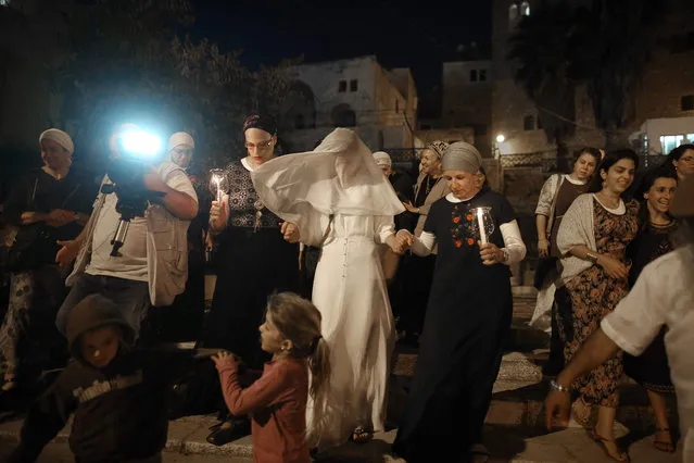 Israeli settler bride Yael Levi is escorted by friends and relatives during her wedding ceremony at the plaza outside the Cave of the Patriarchs also known as the Ibrahimi Mosque, which is a holy shrine for Jews and Muslims, in the heart of the divided city of Hebron in the southern West Bank, on September 22, 2016. (Photo by Menahem Kahana/AFP Photo)