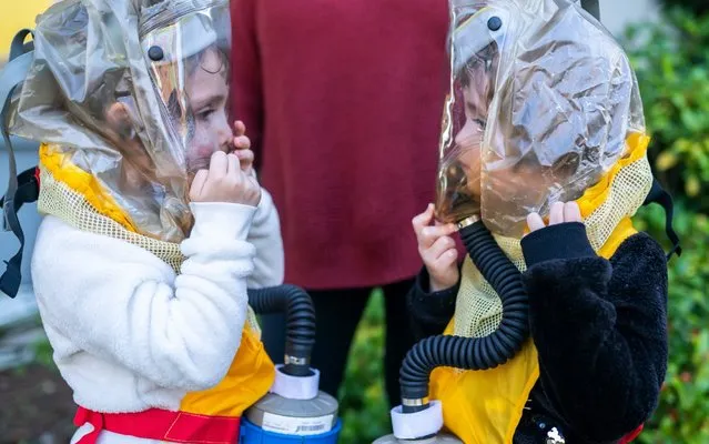 Twins Buddy Mae Walker (L) and Eleanor Walker (R), 4 examine eachother through their child respirators provided by the non-profit TeamRaccoonPDX on October 6, 2020 in Portland, Oregon. We told them their grandparents sent them space suits to keep them safe, their mother Jessica Walker said of the respirators, which the family sought out after police used tear gas near their residential street. (Photo by Nathan Howard/Getty Images)