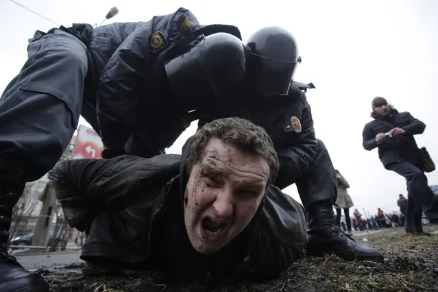 Interior Ministry members detain a man during a protest rally held by opposition activists and members of the Other Russia movement in St. Petersburg, in this February 15, 2014 file photo. (Photo by Maxim Zmeyev/Reuters)