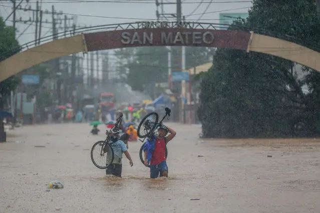 Residents wade through the flood brought by typhoon Vamco in Rizal Province, the Philippines, on November 12, 2020. (Photo by Rouelle Umali/Xinhua News Agency)