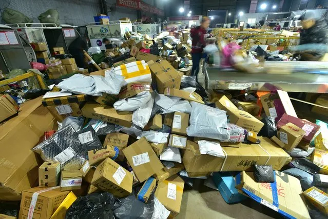 Staff of a local logistics center are busy at organizing goods, preparing to deliver them for customers who ordered during the Double 11, also known as the Singles' Day, an e-commerce shopping festival, Neijiang city, southwest China's Sichuan province, 15 November 2020. (Photo by Rex Features/Shutterstock)