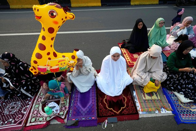 Muslims attend for Eid al-Adha prayer on a street in Jakarta, Indonesia, Monday, June 17, 2024. Muslims around the world celebrate Eid al-Adha by sacrificing animals to commemorate the prophet Ibrahim's faith in being willing to sacrifice his son. (Photo by Achmad Ibrahim/AP Photo)