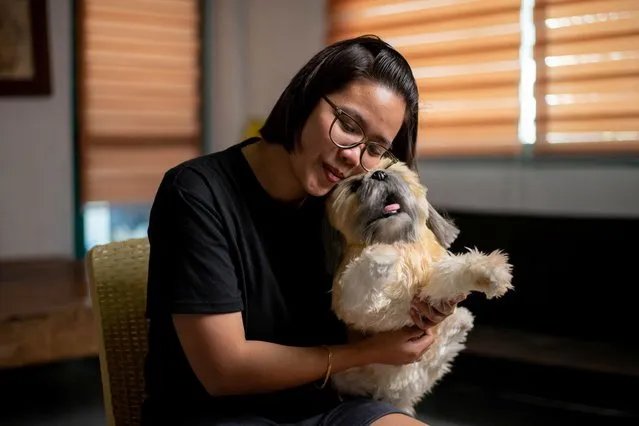 Herminhilda del Rosario poses for a picture with a realistic pet plushie of her departed dog Luna, at her home in Hagonoy town, Bulacan province, Philippines on March 16, 2023. (Photo by Lisa Marie David/Reuters)
