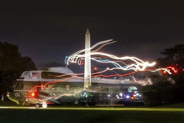 This time exposure shows the light trails as Marine One, carrying U.S. President Donald Trump, lands on the South Lawn of the White House in Washington, late Saturday, April 28, 2018. (Photo by J. David Ake/AP Photo)