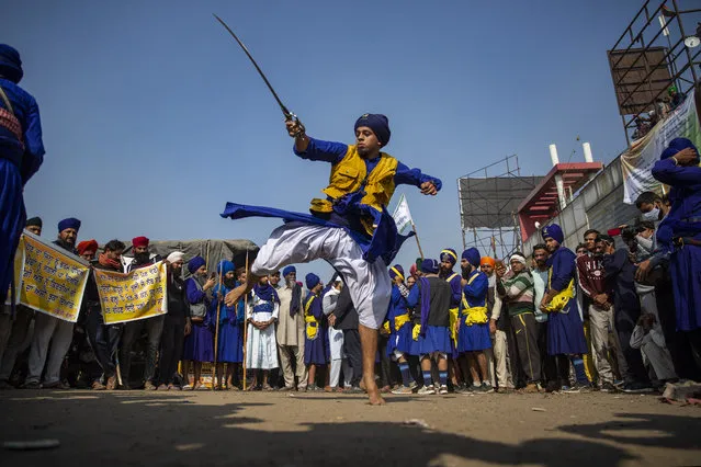 A nihang or a Sikh warrior displays his Sikh martial art skills during a nationwide shutdown called by thousands of Indian farmers protesting new agriculture laws, at the Delhi-Haryana state border, India, Tuesday, December 8, 2020. The strike follows five rounds of talks between the farmers and the Indian government that have failed to produce any breakthroughs. The farmers say the laws will lead the government to stop buying grain at minimum guaranteed prices and result in exploitation by corporations that will push down prices. (Photo by Altaf Qadri/AP Photo) 