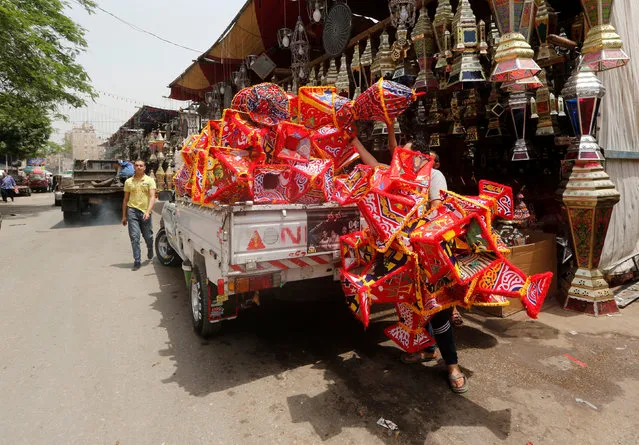 A vendor carries traditional Ramadan lanterns called “famous” are displayed for sale at a stall ahead of the Muslim holy month of Ramadan in old Cairo, Egypt May 2, 2018. (Photo by Amr Abdallah Dalsh/Reuters)