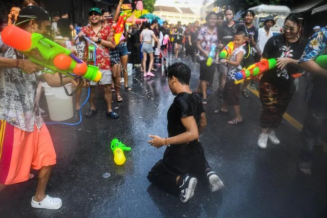 People play with water as they celebrate during the Songkran holiday which marks the Thai New Year in Bangkok, Thailand on April 13, 2023. (Photo by Chalinee Thirasupa/Reuters)