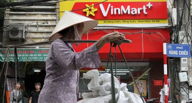 A woman walks past a Vinmart shop in Hanoi, Vietnam, October 12, 2015. (Photo by Reuters/Kham)