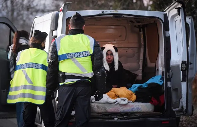 A reveller wearing a panda hat sits in the back of a van after being questioned by the French Gendarme following the break up of a dance rave near a disused hangar in Lieuron about 40km (around 24 miles) south of Rennes, on January 2, 2021. Some 2,500 partygoers attended an illegal New Year rave in northwestern France, violently clashing with police who failed to stop it and sparking concern the underground event could spread the coronavirus, authorities said Friday. (Photo by Jean-Francois Monier/AFP Photo)