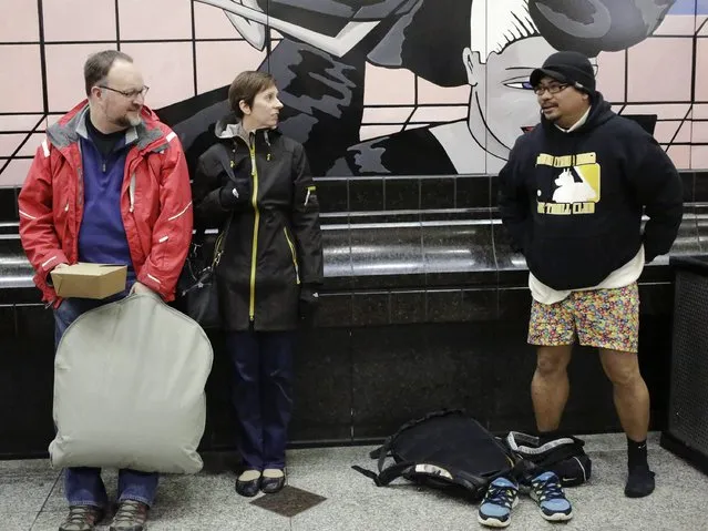 A man (R) takes off his pants at the Westlake light rail station during the annual No Pants Light Rail Ride organized by the Emerald City Improv group in Seattle, Washington January 11, 2015. (Photo by Jason Redmond/Reuters)