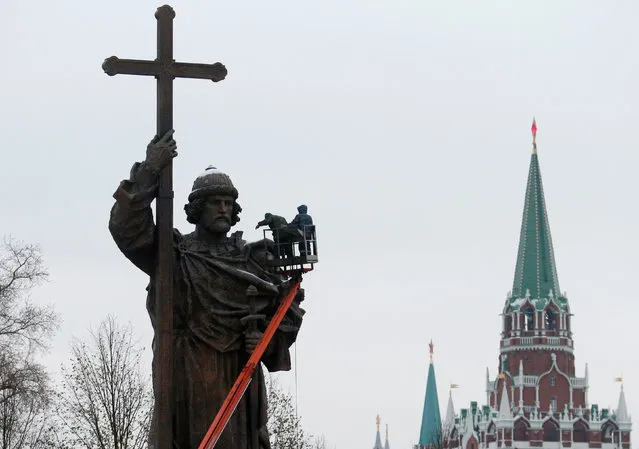 Employees work on the newly erected monument of grand prince Vladimir I, who initiated the christianization of Kievan Rus' in 988AD, with towers of the Kremlin seen in the background, in central Moscow, Russia, November 2, 2016. (Photo by Maxim Zmeyev/Reuters)
