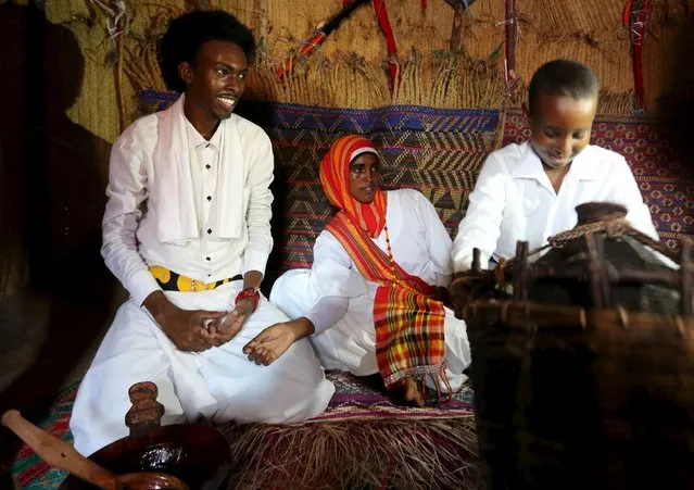 A Somali family sits inside a traditional house during an event to showcase traditional Somali culture in Hamarweyne district in the capital Mogadishu, December 3, 2015. (Photo by Feisal Omar/Reuters)