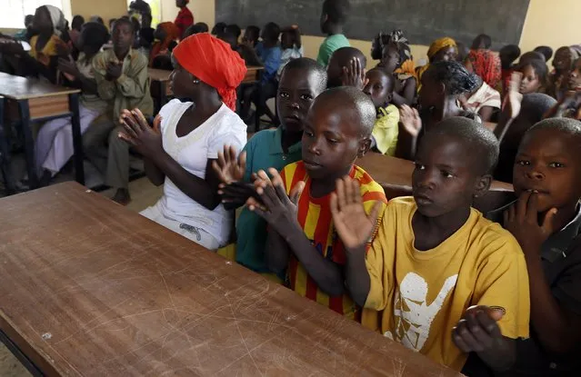 Children displaced as a result of Boko Haram attacks in the northeast region of Nigeria, clap during a class at Maikohi secondary school camp for internally displaced persons (IDP) in Yola, Adamawa State January 13, 2015. (Photo by Afolabi Sotunde/Reuters)