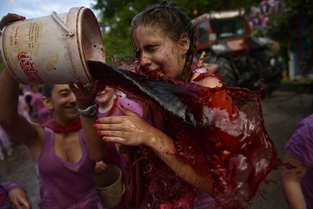 A female is doused with wine as people take part in a wine battle, in the small village of Haro, northern Spain, Friday, June 29, 2018. (Photo by Alvaro Barrientos/AP Photo)