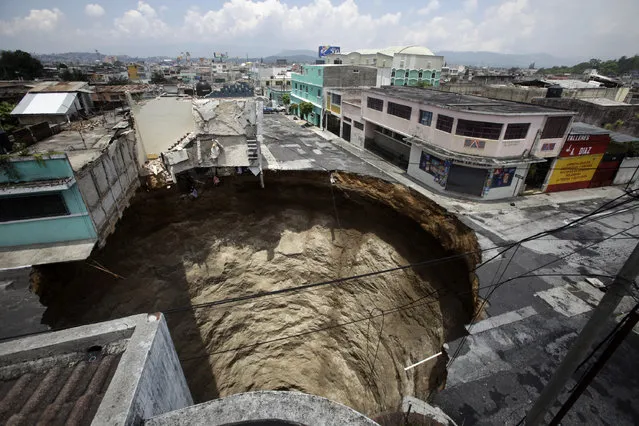 A giant sinkhole caused by the rains of tropical storm Agatha is seen in Guatemala City June 1, 2010.  Collapsed roads and highway bridges complicated rescue efforts in Guatemala on Tuesday after Tropical Storm Agatha drenched Central America, burying homes under mud and killing at least 175 people. (Photo by Daniel LeClair/Reuters via The Atlantic)