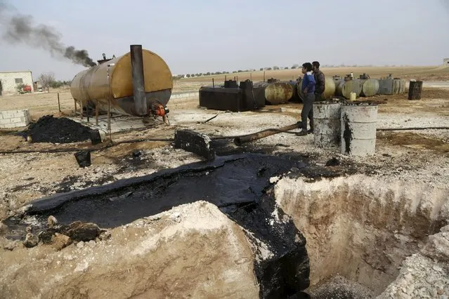 Men work at a makeshift oil refinery site in Marchmarin town, southern countryside of Idlib, Syria December 16, 2015. (Photo by Khalil Ashawi/Reuters)