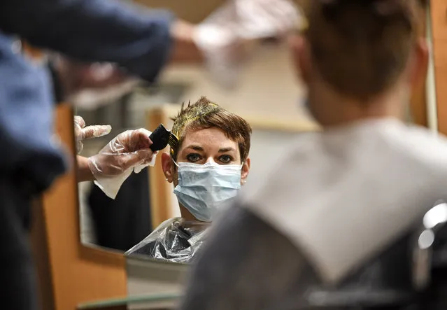 A customer gets her hair colored by a hairdresser at a barber shop in Gelsenkirchen, Germany, Monday, March 1, 2021. Hairdressers across Germany have reopened for business this morning after a more than 2-month closure, another cautious step as the country balances a desire to loosen restrictions with concern about the impact of more contagious coronavirus variants. (Photo by Martin Meissner/AP Photo)