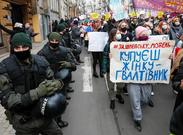 Servicemen of the National Guard stand in the street as activists take part in a rally for gender equality and against violence towards women on International Women's Day in Kyiv, Ukraine on March 8, 2021. (Photo by Gleb Garanich/Reuters)