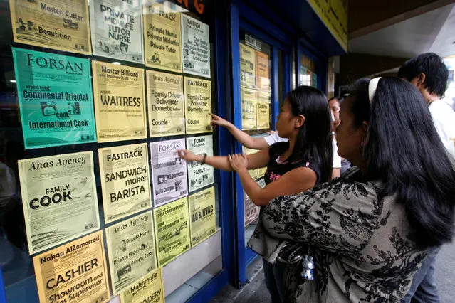 Applicants look at job offers displayed on a glass window of a recruitment agency in Manila in this October 9, 2010 file photo. (Photo by Cheryl Ravelo/Reuters)