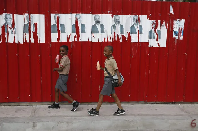Two kids walks next to propaganda of the campaign of the Haitian presidential candidate Jovenel Moise, in Port-au-Prince, Haiti, 21 January 2016. Haitian President Michel Martelly agreed to call off the second round of the presidential elections on next Sunday 24 January if someone provides an alternative proposal. Martelly adressed the country thorugh a televised message after the Senate voted for a recommendation to postpone the elections. (Photo by Orlando Barria/EPA)