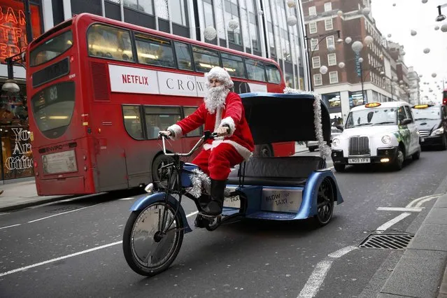 A man in a Santa Claus costume rides a cycle taxi along Oxford Street in London, Britain December 18, 2016. (Photo by Neil Hall/Reuters)