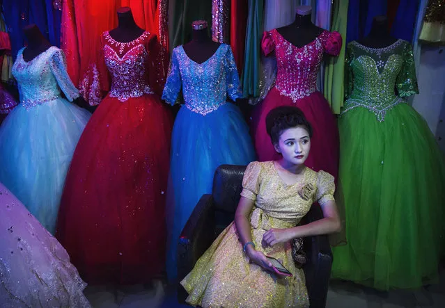An ethnic Uyghur girl waits in a beauty salon to have her hair done before the Corban festival on September 8, 2016 in Turpan County, in the far western Xinjiang province, China. The Corban festival, known to Muslims worldwide as Eid al-Adha or “feast of the sacrifice”, is celebrated by ethnic Uyghurs across Xinjiang, the far-western region of China bordering Central Asia that is home to roughly half of the country's 23 million Muslims. The festival, considered the most important of the year, involves religious rites and visits to the graves of relatives, as well as sharing meals with family. Although Islam is a 'recognized' religion in the constitution of officially atheist China, ethnic Uyghurs are subjected to restrictions on religious and cultural practices that are imposed by China's Communist Party. Ethnic tensions have fueled violence that Chinese authorities point to as justification for the restrictions. (Photo by Kevin Frayer/Getty Images)