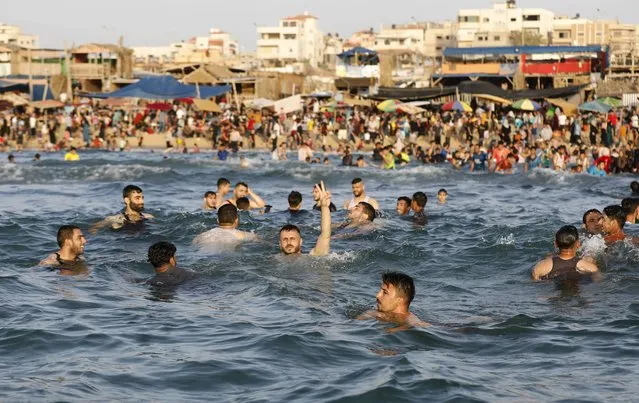 Palestinians enjoy the beach of the Mediterranean sea in Gaza City, Friday, May 28, 2021. The beach is one of the few open public spaces in this densely populated city. (Photo by Hatem Moussa/AP Photo)