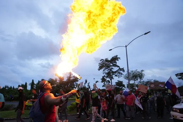 A fire eater joins a march protesting against a recently approved mining contract between the government and Canadian mining company First Quantum, in Panama City, Wednesday, October 25, 2023. (Photo by Arnulfo Franco/AP Photo)
