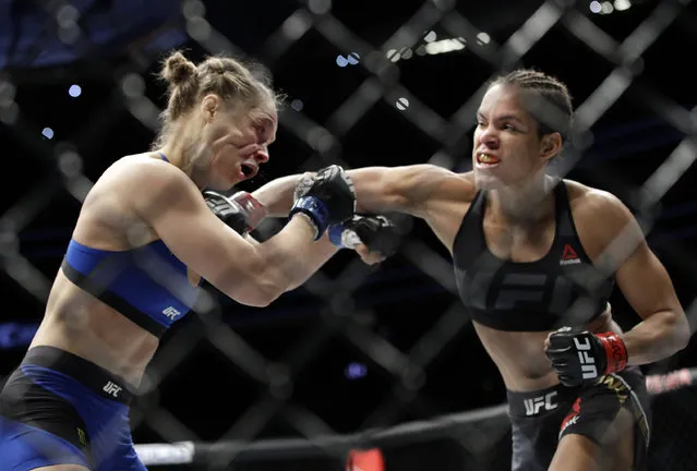 Amanda Nunes, right, connects with Ronda Rousey in the first round of their women's bantamweight championship mixed martial arts bout at UFC 207, Friday, December 30, 2016, in Las Vegas. Nunes won the fight after it was stopped in the first round. (Photo by John Locher/AP Photo)
