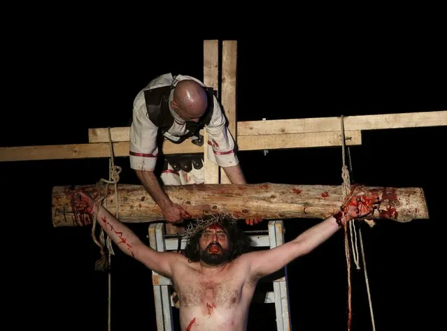 An actor portraying the crucified Jesus Christ takes part in the interactive street-theatre performance of Il-Mixja (The Way) in Attard, outside Valletta, March 31, 2015. The Passion play was held in the grounds of Mount Carmel Mental Hospital as part of a series of Holy Week activities in the run-up to Easter taking place all over Malta. (Photo by Darrin Zammit Lupi/Reuters)