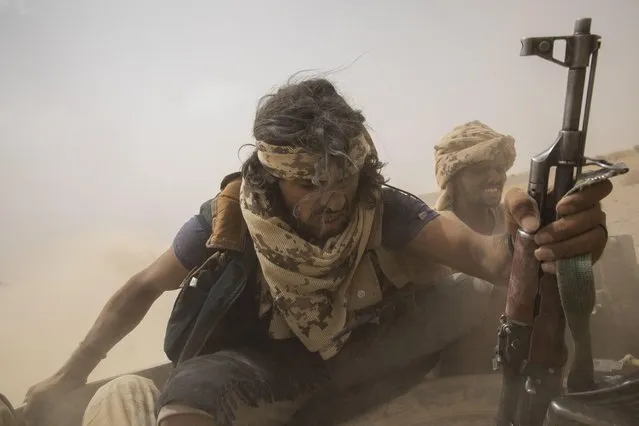 Yemeni fighters backed by the Saudi-led coalition ride on the back of an armored vehicle as they leave the front lines of Marib, Yemen, Saturday, June 19, 2021. (Photo by Nariman El-Mofty/AP Photo)